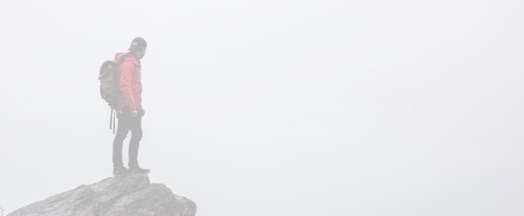 a man standing on a mountain gliff